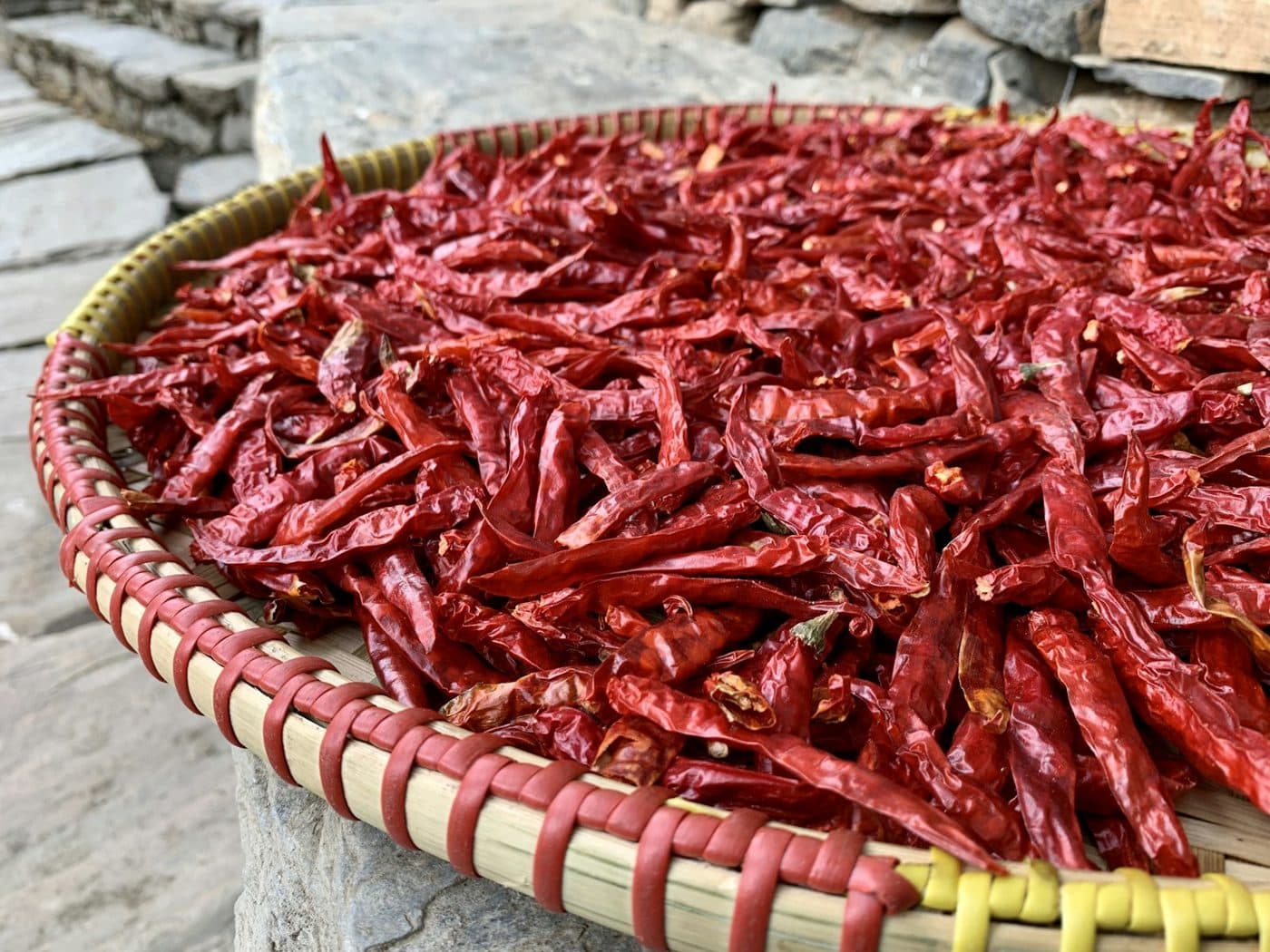 A woven basket of red chillies drying in the sun